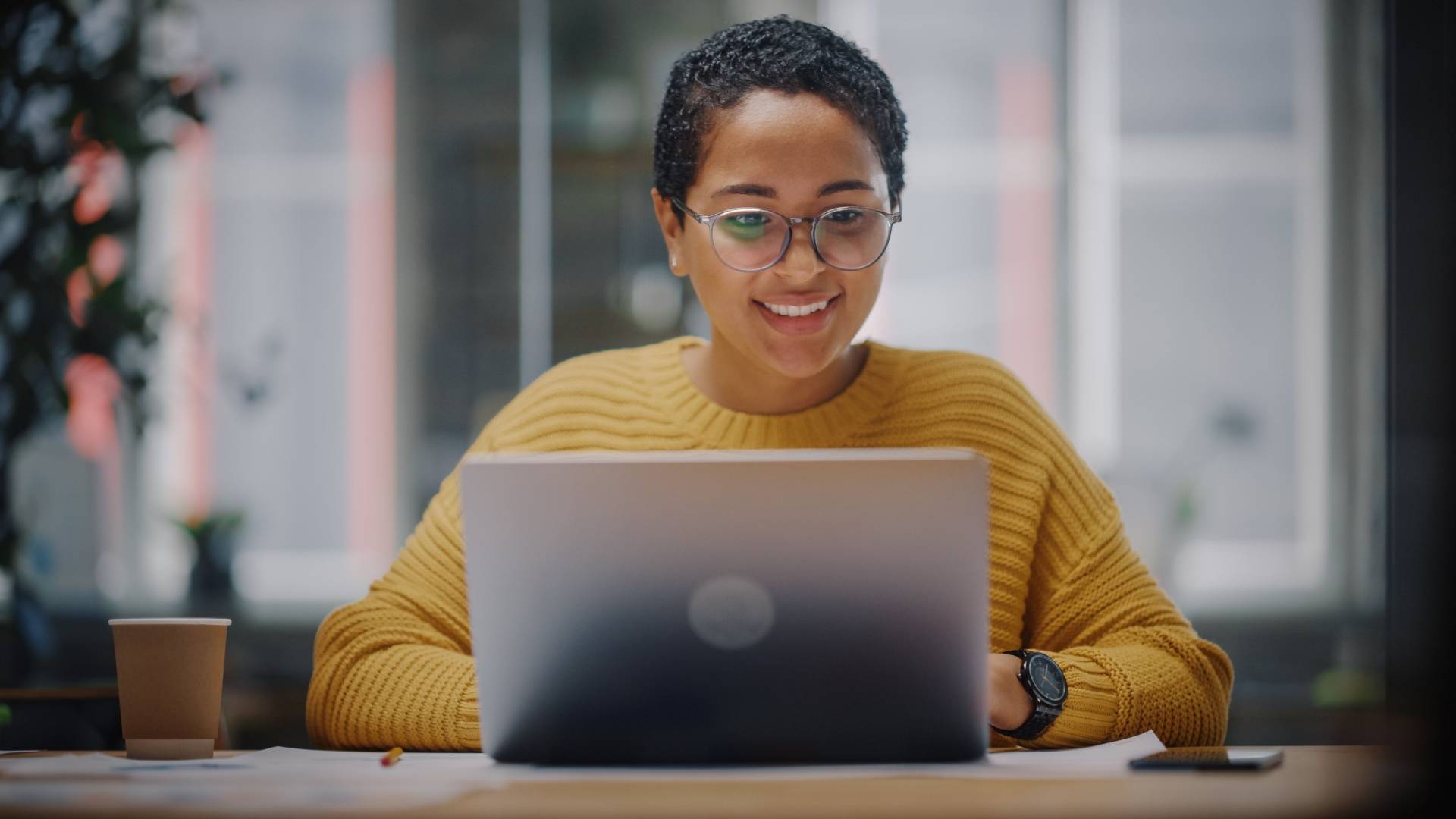 Happy female professional working at laptop