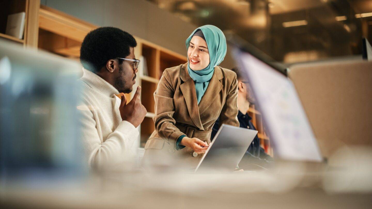 Male and female corporate professionals talking in an office