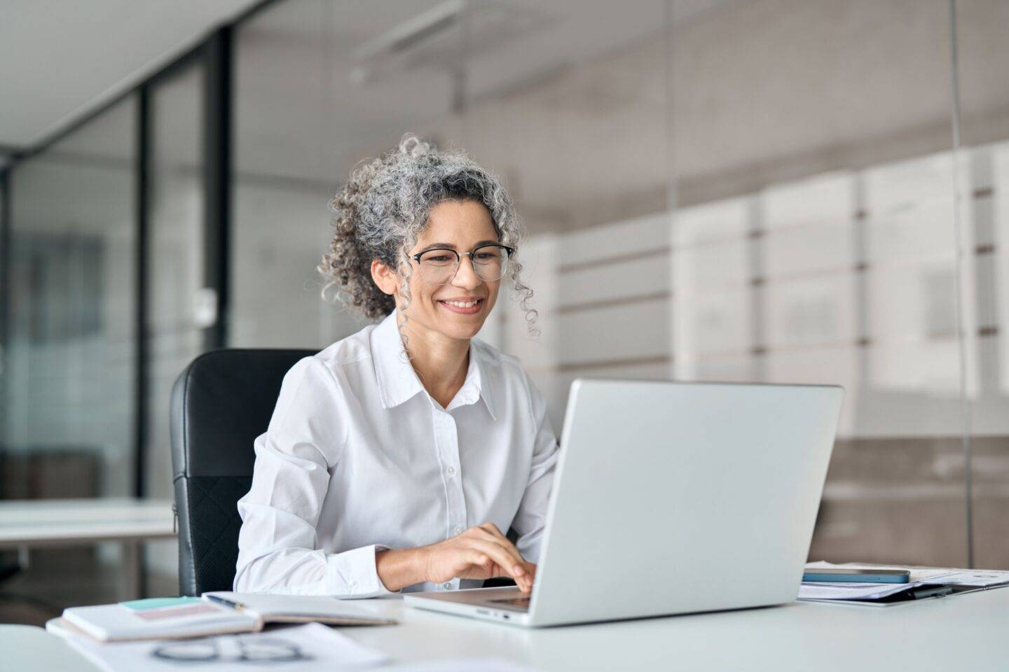 Older female professional smiling while working in an office